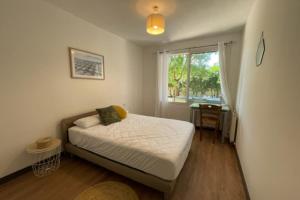 a small bedroom with a bed and a window at Spacious cocoon with pool in La Rochelle in La Rochelle +8 photos