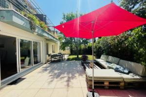 a red umbrella sitting on top of a patio at Spacious cocoon with pool in La Rochelle in La Rochelle