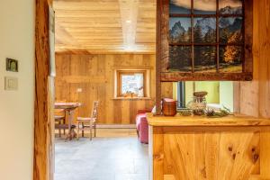 eine Küche mit Holzwänden und ein Esszimmer in der Unterkunft Lo Mayen in Auri Grande