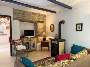 a living room with a couch and a tv at Casa Vigneto - Villa With Pool in Toano