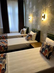 a hotel room with three beds in it at Hotel Santal in Bukhara