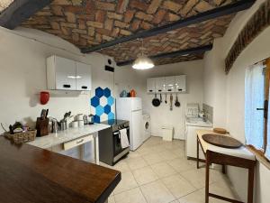 a kitchen with white appliances and a brick ceiling at Casa Vigneto - Villa With Pool in Toano