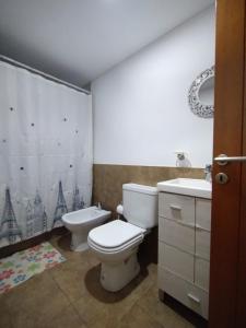 a bathroom with a toilet and a sink at Dptos CipoTerra in Cipolletti