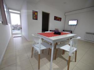 a white table and chairs in a room at Dptos CipoTerra in Cipolletti