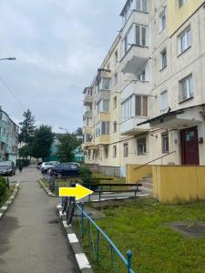 a yellow arrow sign on a fence next to a building at Apartament Tudor in Făgăraş