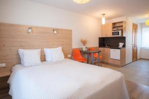 a bedroom with a bed and a table and a kitchen at Nida Inn Self Check-in in Nida