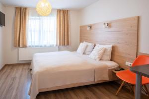 a bedroom with a large bed and a table and chair at Nida Inn Self Check-in in Nida