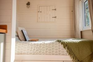 a room with a bed with a laptop on it at Hazel Boutique Shepherds Hut Cotswolds in Cirencester