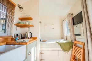 a tiny kitchen in a tiny house with a counter top at Hazel Boutique Shepherds Hut Cotswolds in Cirencester