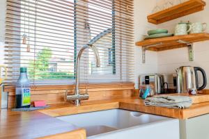 a kitchen with a sink and a counter top at Hazel Boutique Shepherds Hut Cotswolds in Cirencester +13 photos