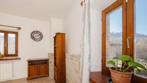 a room with a clock on the wall and a plant at ERmETE in Tortona