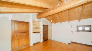 an empty room with wooden ceilings and a wooden door at ERmETE in Tortona