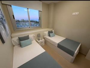 a small bedroom with two beds and a window at Costa Azahar - En Primera Línea in El Borseral +34 photos