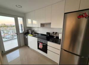 a kitchen with a stainless steel refrigerator and a window at Costa Azahar - En Primera Línea in El Borseral