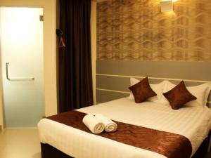 a hotel room with a bed with two towels on it at Rock & Roll Hotel Klang in Klang