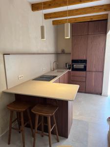 a kitchen with wooden cabinets and a counter with stools at Campet50 in Felanitx +30 photos