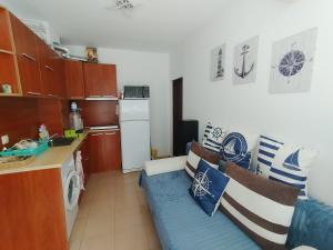 a small kitchen with a blue couch in a room at SEA SKY View in Byala