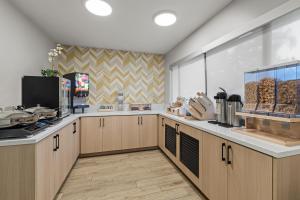 a kitchen with wooden cabinets and a counter top at City Express by Marriott Mountain View - Sunnyvale in Mountain View