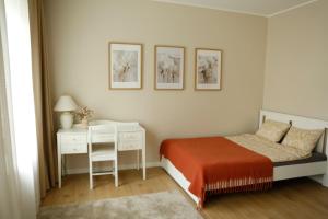 a white bedroom with a bed and a desk at Center of city apartments, bus station 1min, airport 5 min in Tallinn