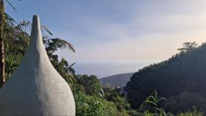 a stone wall with a view of a mountain at Arambha ecovillage farmstay in Tábua