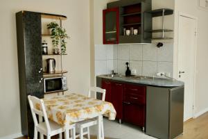 a kitchen with a sink and a table with chairs at Center of city apartments, bus station 1min, airport 5 min in Tallinn