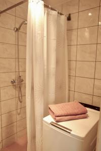 a white shower curtain with a towel on top of a toilet at Center of city apartments, bus station 1min, airport 5 min in Tallinn