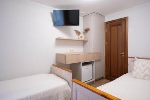 a small room with two beds and a tv at Laguna Self Check-in in Nida +65 photos