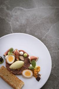 a plate of food with eggs and bread on it at Parkhotel Holzerhof in Maranza