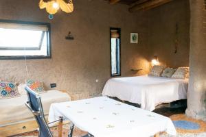 a room with two beds and a table and chairs at Casa Nativa in Mendoza