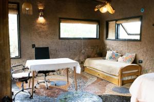 a room with two beds and a table and a desk at Casa Nativa in Mendoza