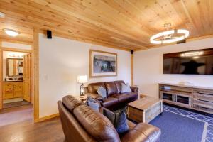 a living room with leather furniture and a flat screen tv at Walk to Flathead Lake! Home w/ Deck & Fenced Yard! in Lakeside