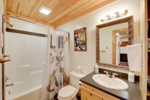a bathroom with a sink and a toilet and a mirror at Walk to Flathead Lake! Home w/ Deck & Fenced Yard! in Lakeside +25 photos