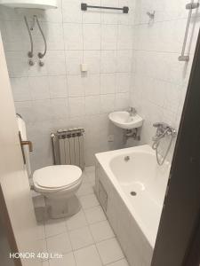a white bathroom with a toilet and a sink at Nedzarici sobe in Sarajevo