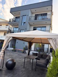 a large tan umbrella in front of a building at Mzeonas Apartment in Kobuleti