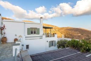 a white house with a mountain in the background at Anastasia Home in Triandáros