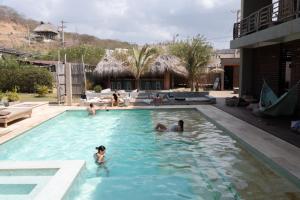 a group of people swimming in a swimming pool at Casa Mambo Salinas in Santa Verónica