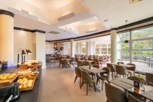 a restaurant with tables and chairs and windows at Intercity Itupeva in Itupeva