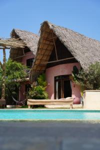 a house with a thatched roof next to a swimming pool at Casa Mambo Salinas in Santa Verónica