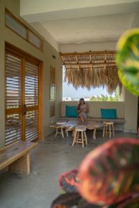 a woman sitting on a bench in a room at Casa Mambo Salinas in Santa Verónica