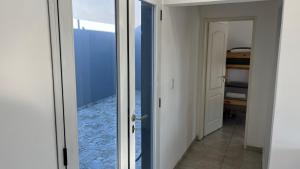 a door to a room with a view of a bedroom at Travel Suites Ezeiza- 5 pax- Centro Eze- Shoppings a 8 min in Ezeiza