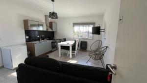 a living room with a black couch and a kitchen at Travel Suites Ezeiza- 5 pax- Centro Eze- Shoppings a 8 min in Ezeiza