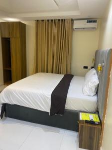 a bedroom with a bed with a black and white blanket at CHASE hotels in Ibadan