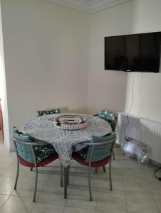 a dining room table with two chairs and a television at Dar Fouzia in Hammamet Sud