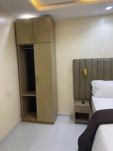 a bedroom with a bed and a cupboard and a bed and a bed sqor at CHASE hotels in Ibadan +7 photos
