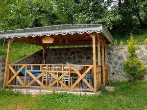 a wooden gazebo with a roof on a stone wall at Cennet bahçesi in Yomra