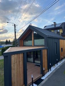 a house with a black roof and a wooden deck at Stodoła Nad Dunajcem in Sromowce Wyżne +14 photos