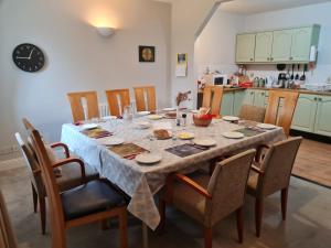 a dining room table with chairs and a kitchen at Glendalough Sanctuary in Brockagh