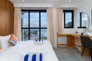 a bedroom with a large bed with a desk and windows at Seaside Oceanview in Ukulhas