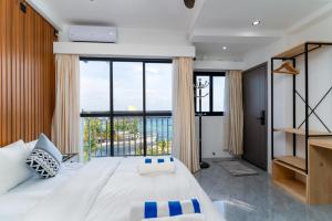 a bedroom with a large bed with a large window at Seaside Oceanview in Ukulhas