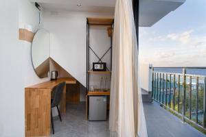 a room with a desk and a balcony with the ocean at Seaside Oceanview in Ukulhas
